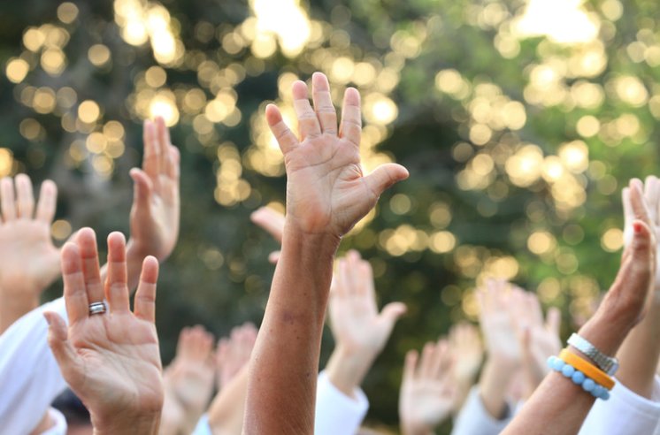 Community gathered with hands raised in worship and praise