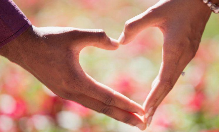 Two hands forming a heart shape, love in action through giving