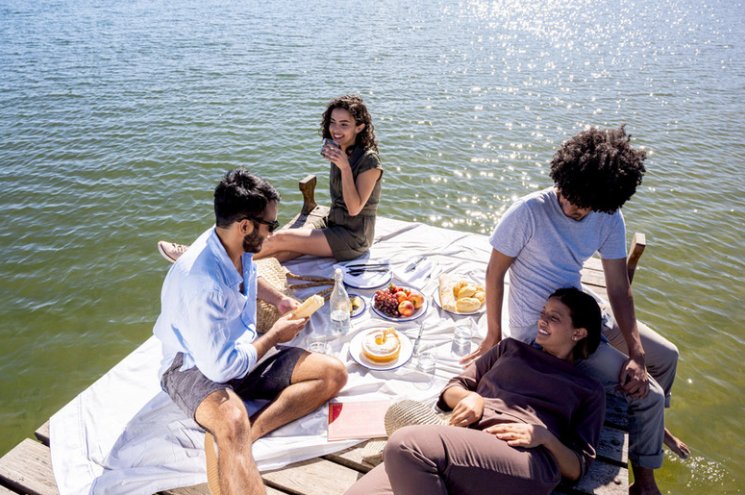 Group of singles gathered for a picnic on the pier, enjoying community